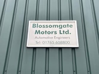 The Blossomgate Motors Ltd. Automotive Engineers sign on the green cladding of the unit
